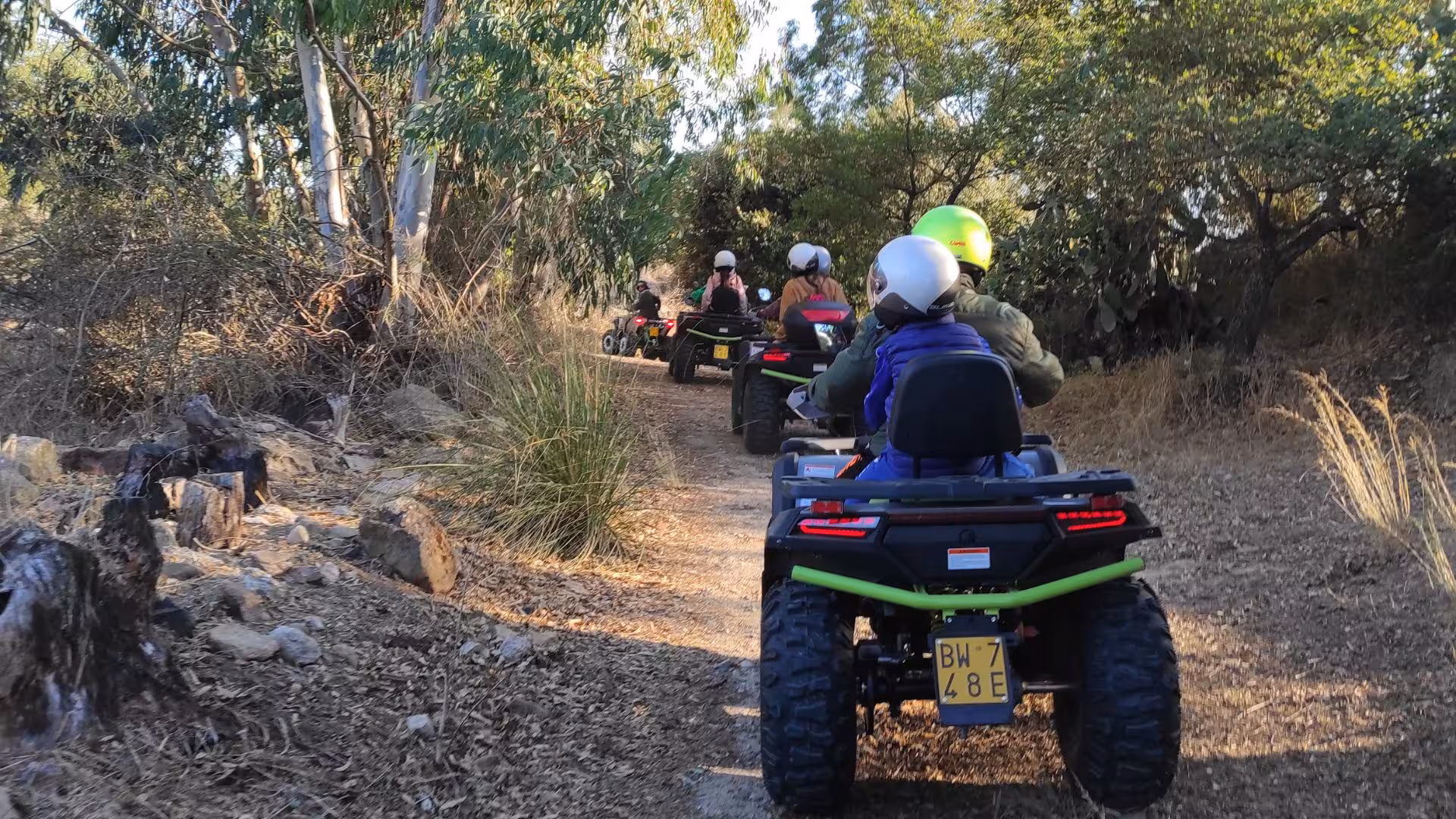 Group of people riding ATVs through a scenic trail near Cagliari during an adventurous Guasila tour.