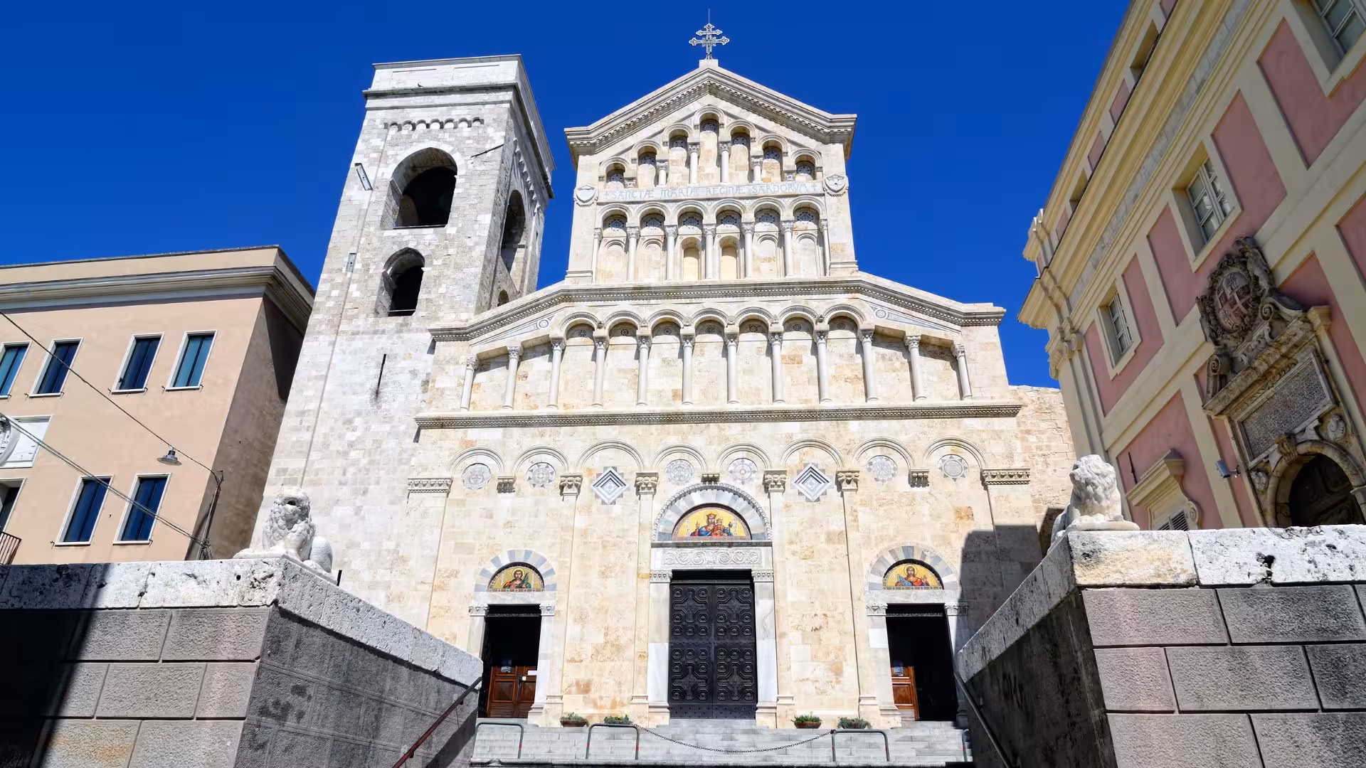 Stunning facade of Cagliari Cathedral under a clear blue sky, showcasing intricate architectural details.