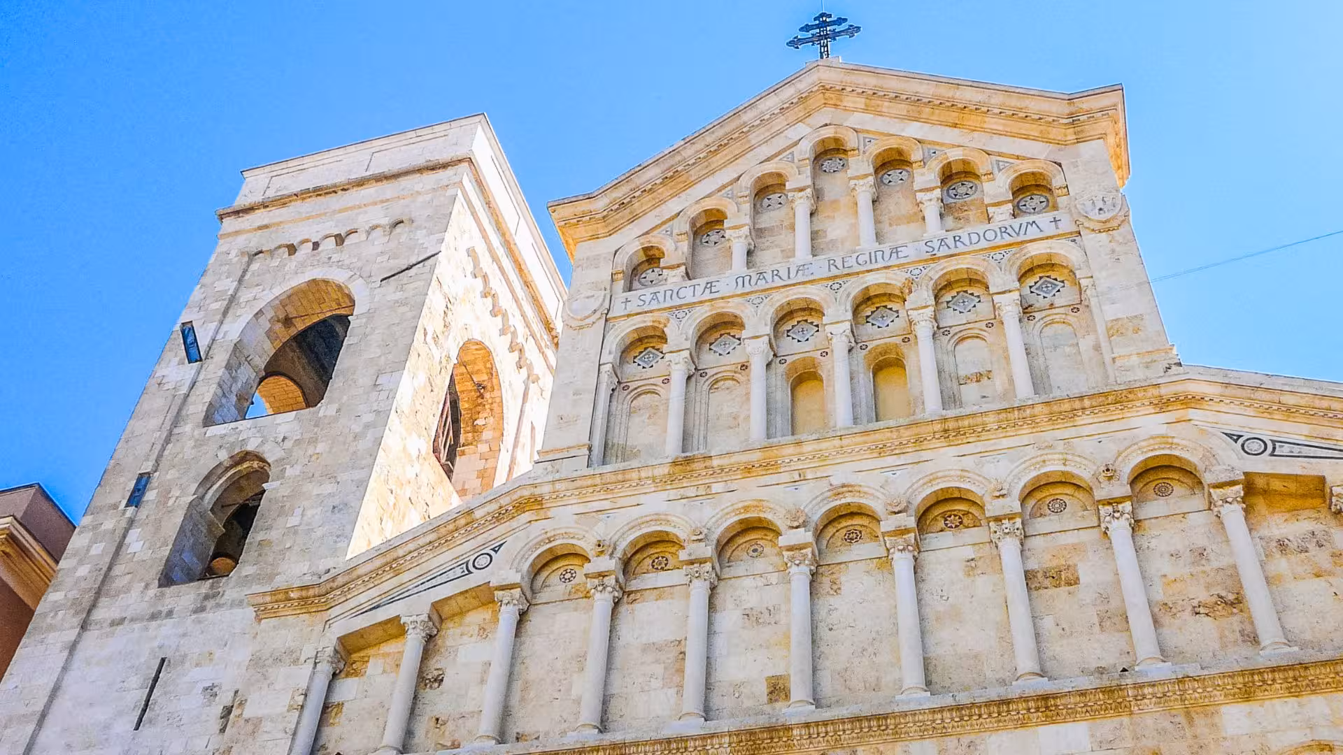 Close-up of Cagliari Cathedral's ornate facade with its historical stonework and majestic tower.