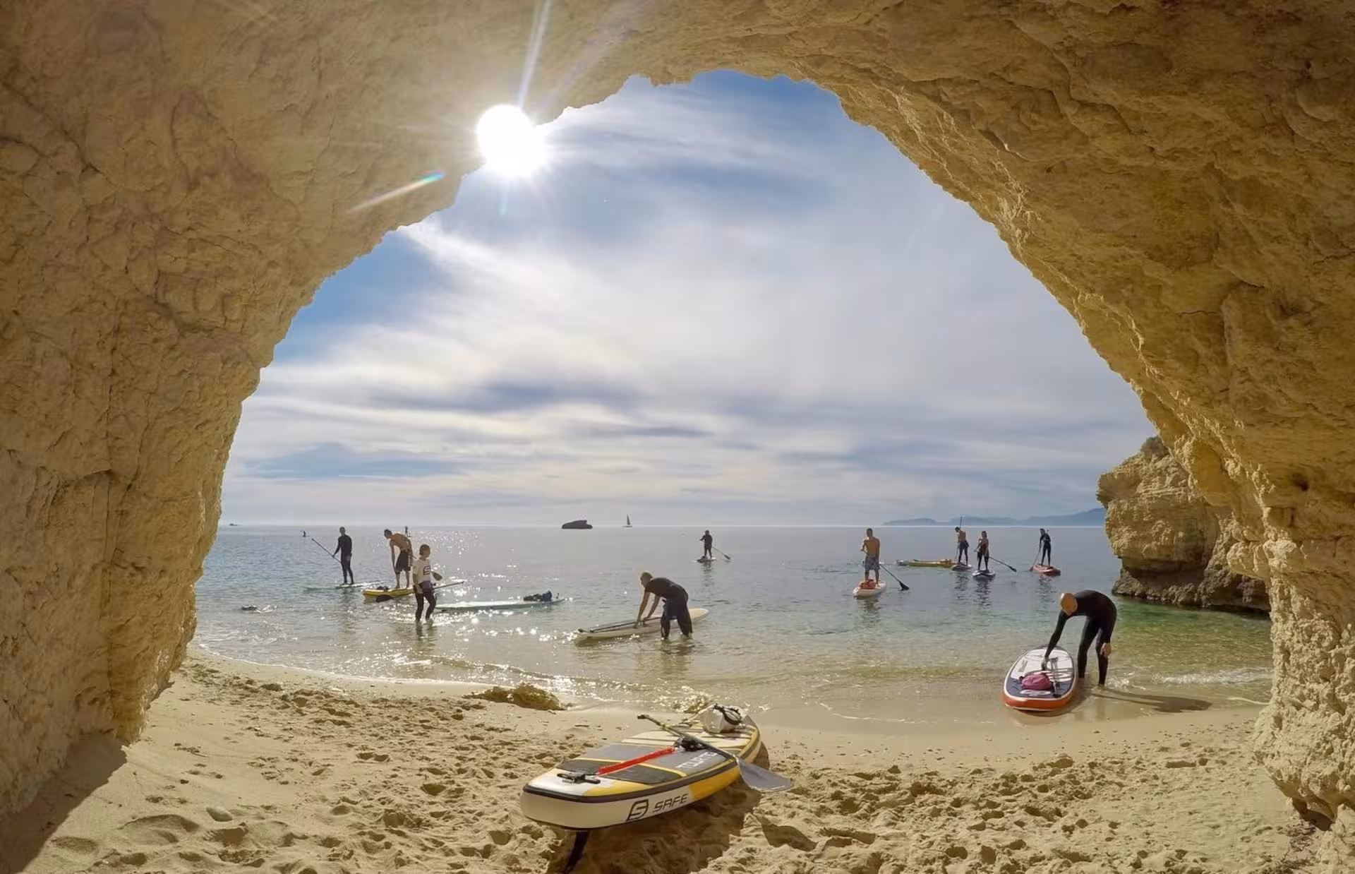Paddleboarders prepare to explore the serene waters from a sandy cove on the Cagliari SUP and snorkelling tour.