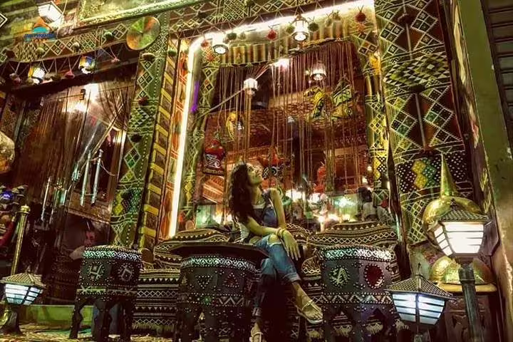 Traveler relaxing at a traditional Cairo bazaar café, colorful décor stop on 2-day Giza and Cairo tour from Alexandria