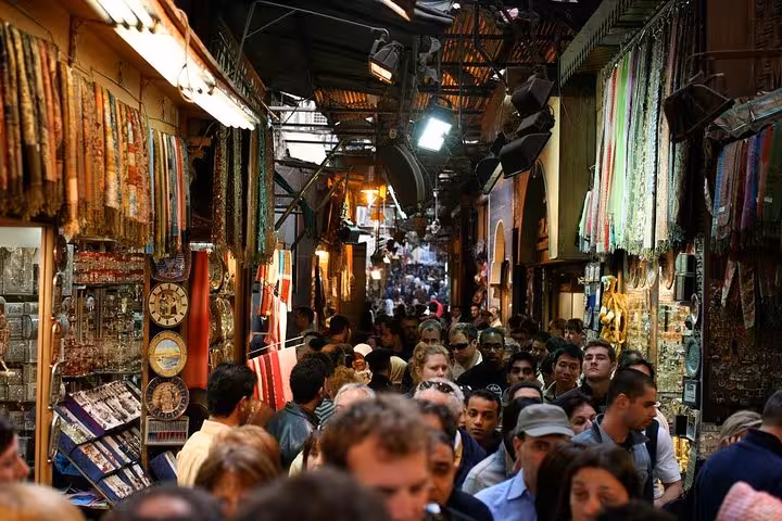Crowded Cairo bazaar shopping alley with souvenirs and textiles on a private Giza pyramids and museum tour