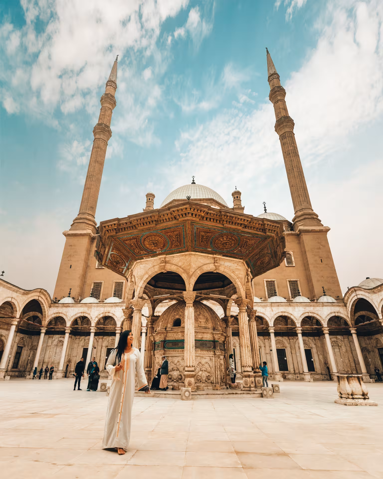Traveler at Cairo Citadel Mosque courtyard with twin minarets, part of 11-day Discover Egypt budget adventure