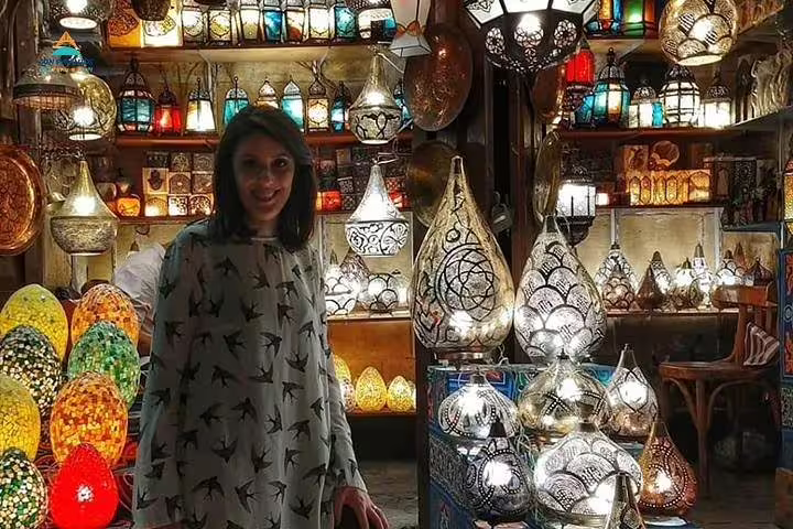 Tourist shopping for colorful lanterns in Cairo Khan El Khalili bazaar, included in 2-day Giza and Cairo tour from Alexandria