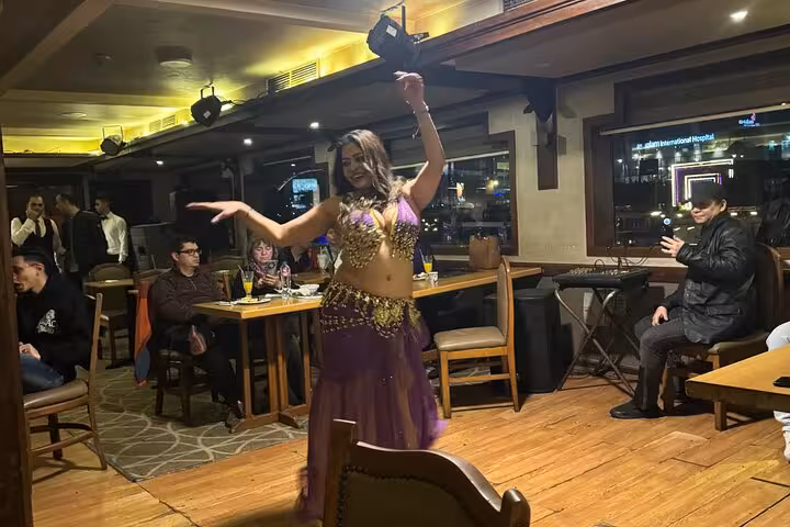 Belly dancer performing on Cairo Nile dinner cruise with hotel pickup, evening entertainment and city lights
