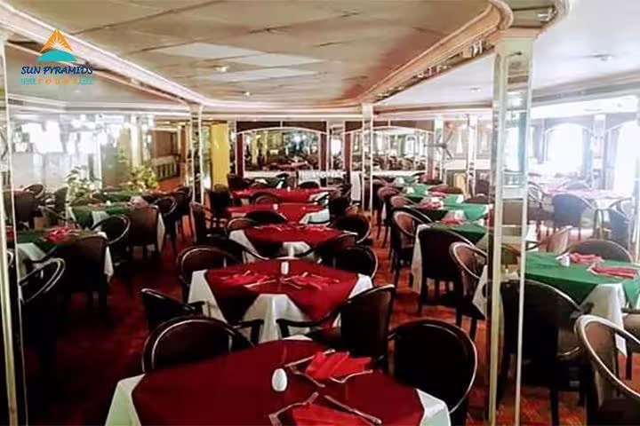 Dining hall on Cairo Nile dinner cruise boat with set tables, buffet seating, and evening show ambience