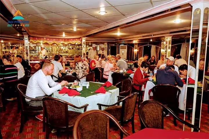 Indoor dining area on Cairo Nile dinner cruise with buffet tables and guests enjoying dinner during night sailing