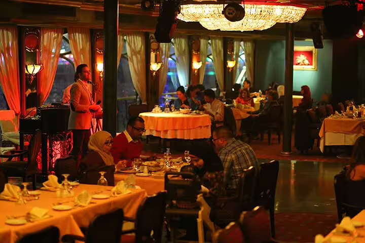 Cairo Nile dinner cruise dining room with live singer and guests, part of Giza Pyramids and museum combo tour