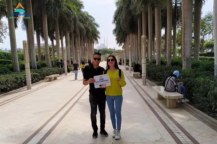 Travelers in a palm-lined Cairo park during a city tour, included in the 4-day Cairo and Red Sea holiday package