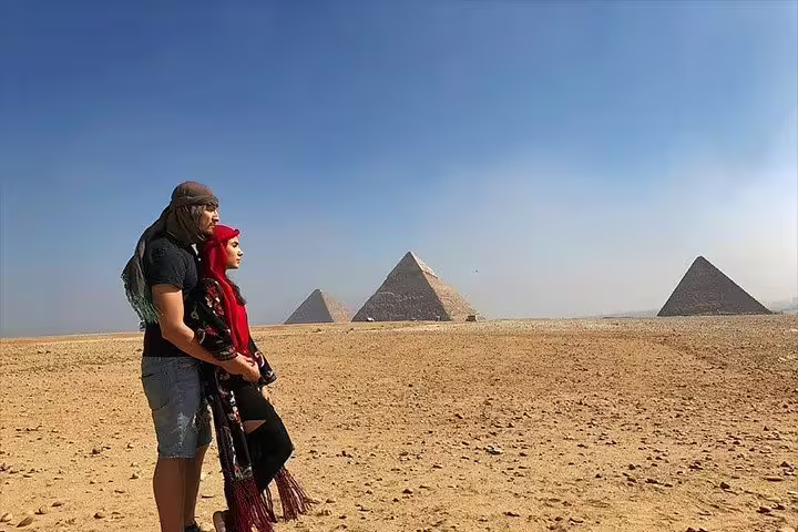 Couple watching the Pyramids of Giza in the desert, a highlight of the 4-day Cairo short break package