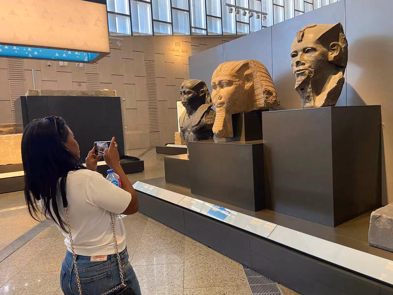 Traveler photographing pharaoh statues at the Grand Egyptian Museum, included in 4 days Cairo tour with accommodation