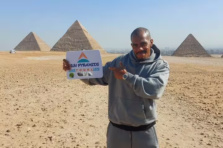 Tour guide posing at Giza Pyramids, private Cairo tour from Marsa Alam by flight with VIP transfers
