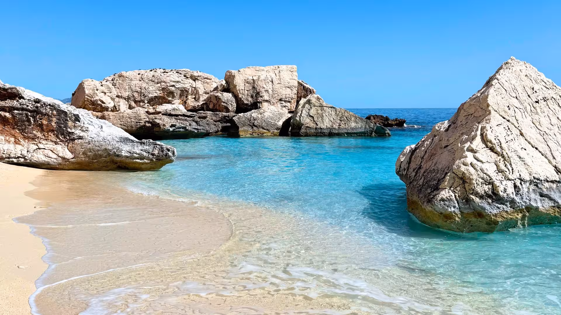 Crystal-clear turquoise waters and rocky formations at a pristine beach in the Gulf of Orosei, perfect for a dinghy trip.