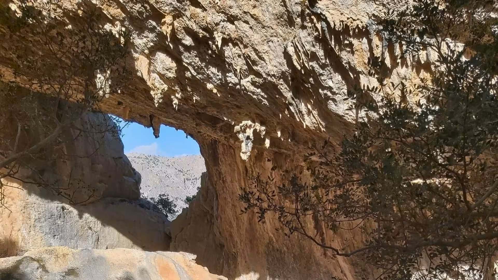 Sunlight filtering through natural rock arch at Tiscali ruins, a highlight of the Cala Gonone trekking tour.