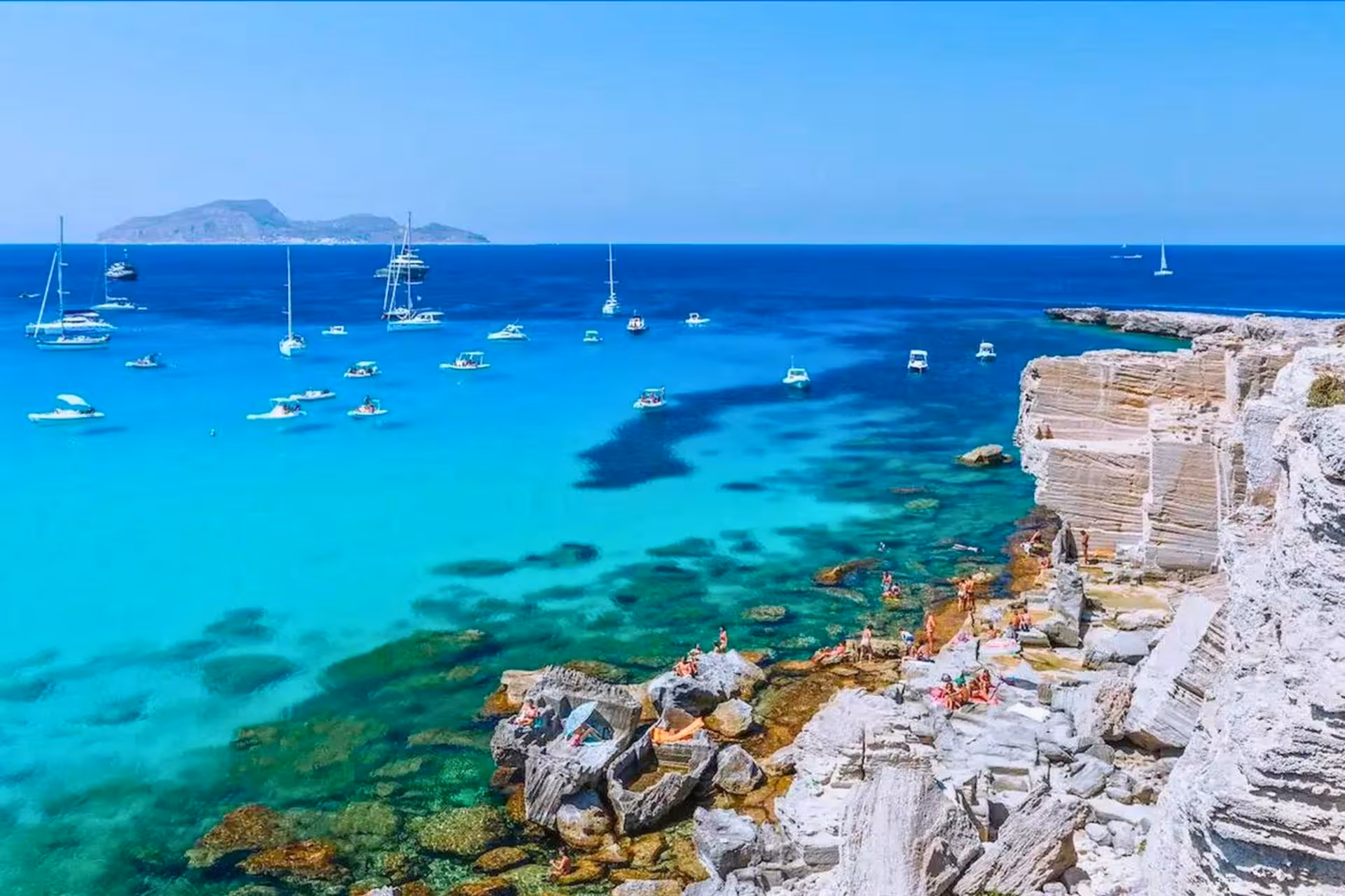 Turquoise Cala Rossa, Favignana with boats at anchor, scenic stop on Egadi Islands dinghy excursion from Trapani