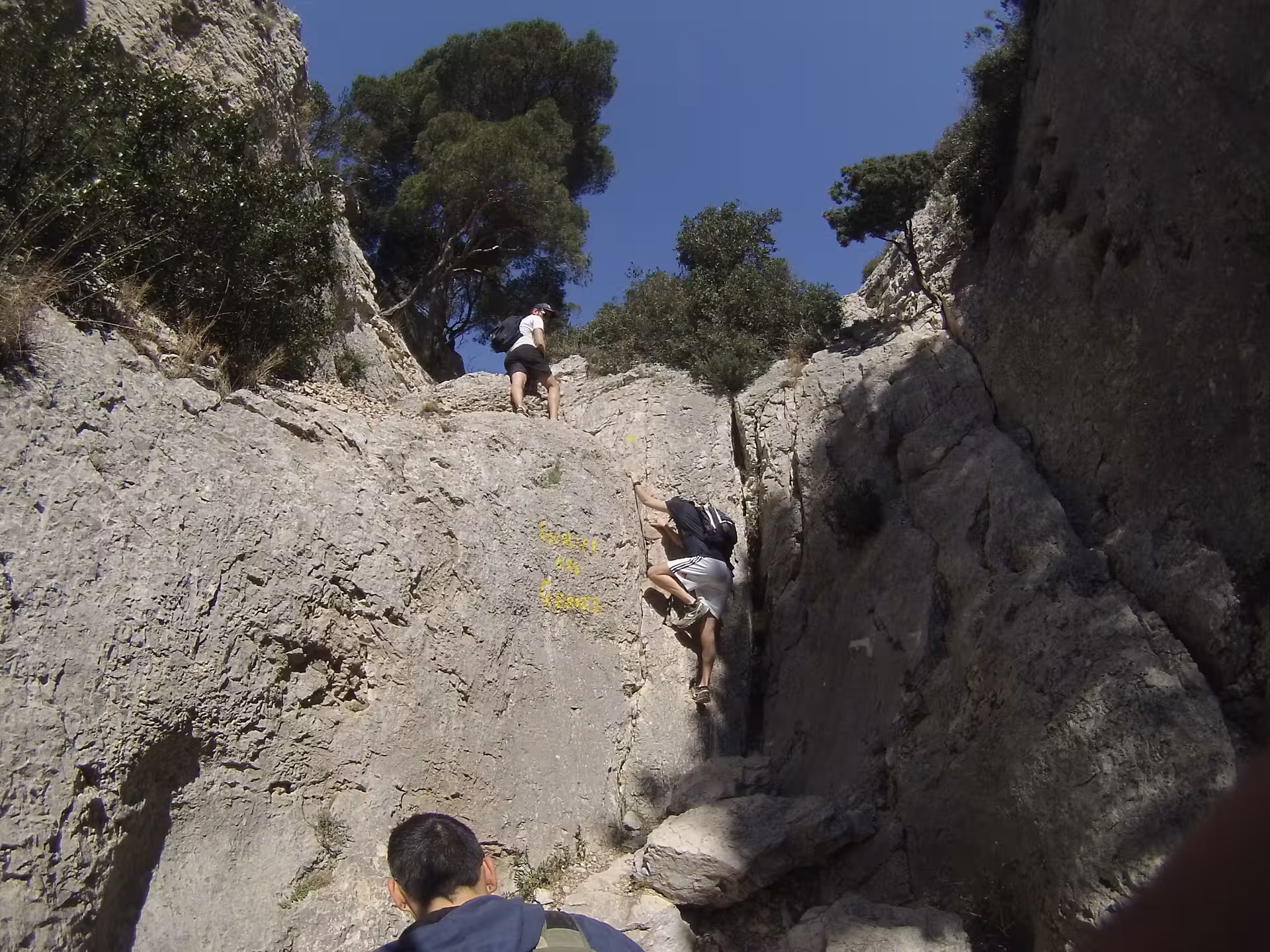 Adventurers scrambling up limestone rocks in the Calanques on a guided 3-day hiking and climbing tour