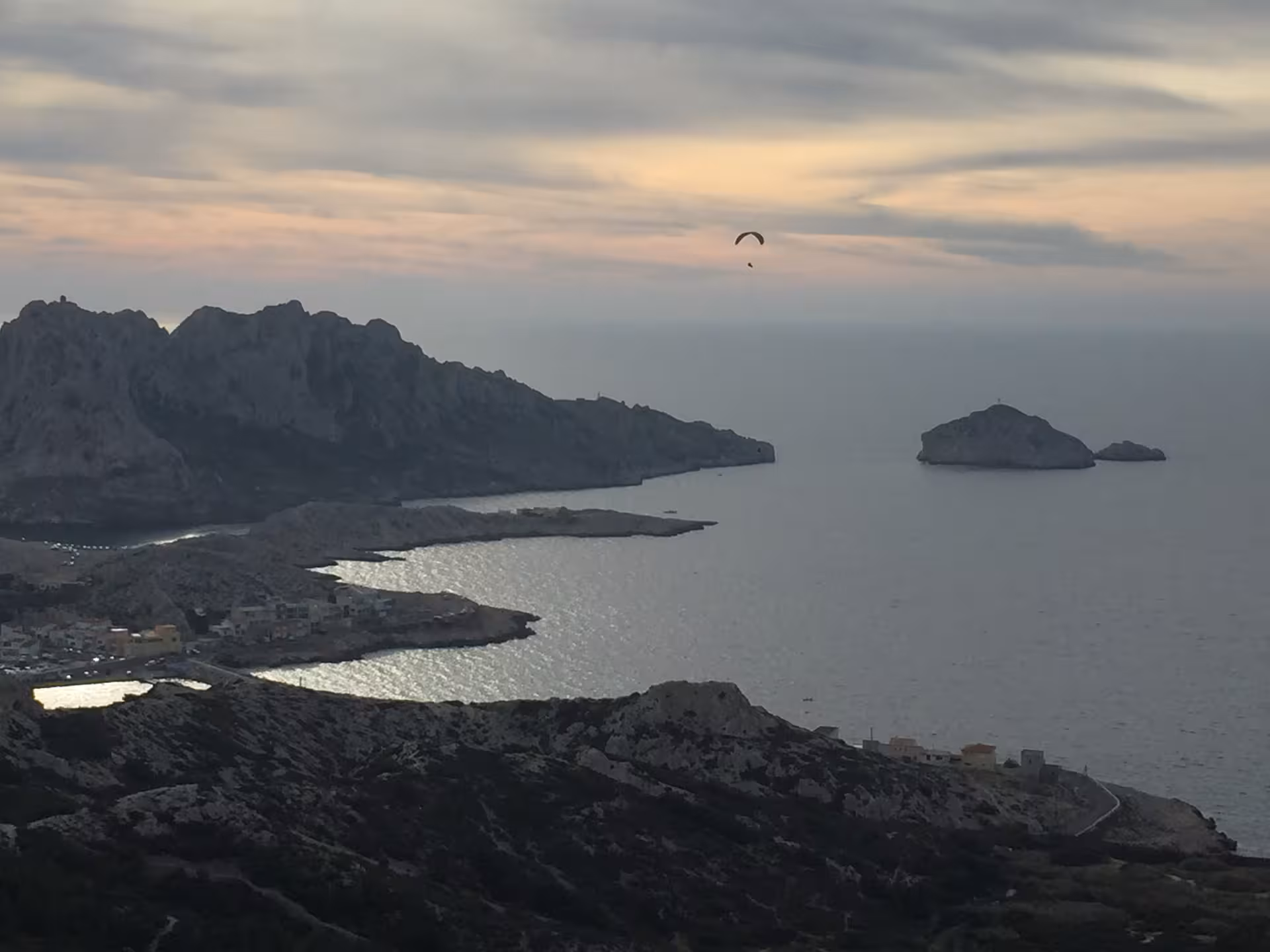 Sunset panorama over Marseille Calanques coastline with a paraglider above the sea on a 3-day tour