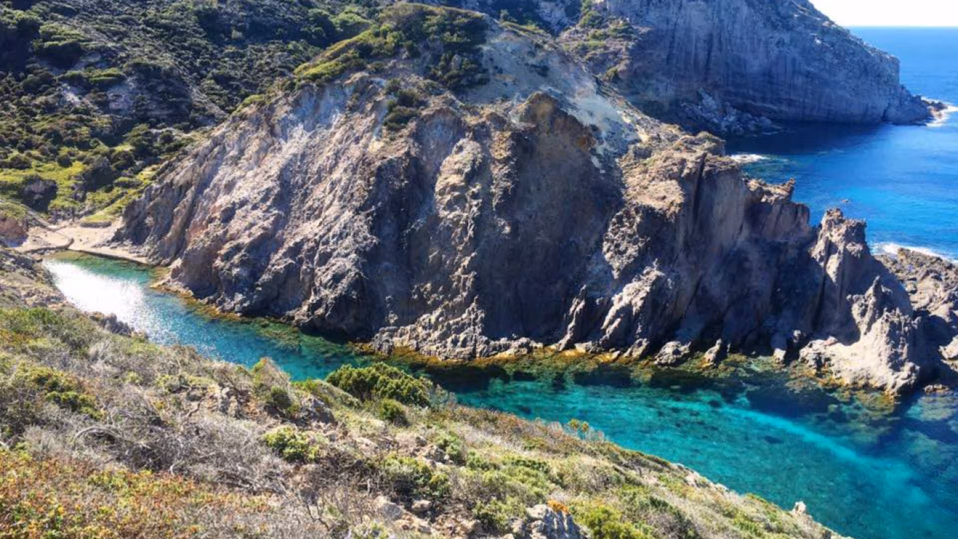 Stunning coastal view of rugged cliffs and turquoise waters near Carloforte on a 4-hour dinghy tour from Calasetta.