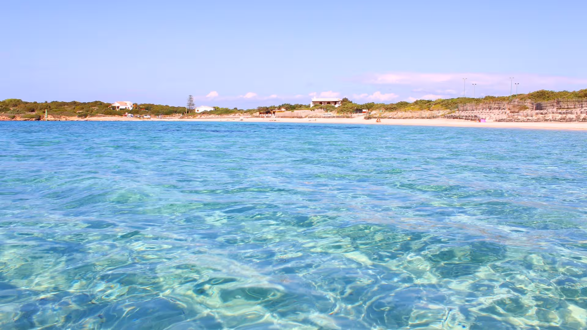 Vibrant turquoise waters and sandy beaches of Calasetta, perfect for a refreshing ebike tour.