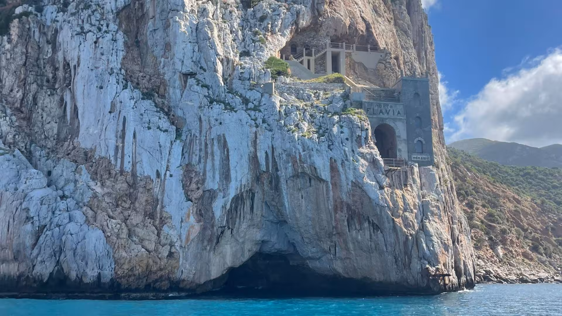 Dramatic cliffside with ancient structures near Calasetta, highlighting stunning RIB hire tour attractions.
