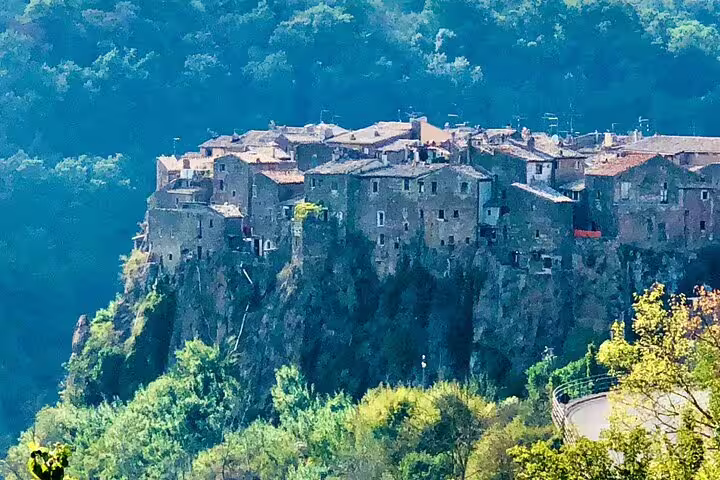 Medieval hilltop village of Calcata perched on dramatic cliffs above lush forest, visited on a Rome VIP private guided day tour