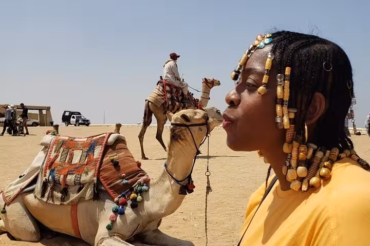 Camel at Giza Plateau with traveler in desert, part of all-inclusive Giza Pyramids, museum and bazaar tour
