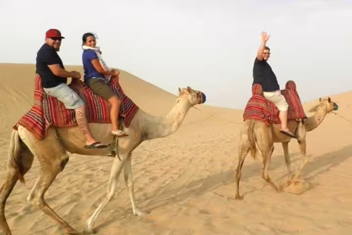 Tourists enjoying camel ride in Marsa Alam desert, part of ATV quad bike safari with Bedouin dinner show