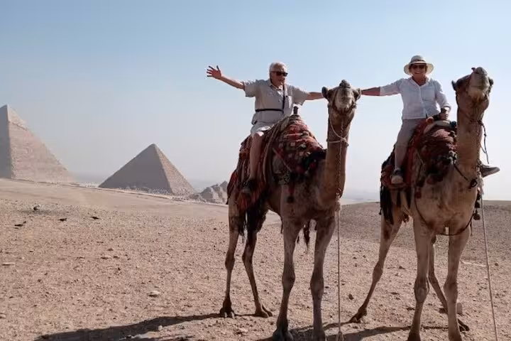 Camel ride at the Giza Pyramids with travelers in the desert on an all-inclusive Cairo day tour