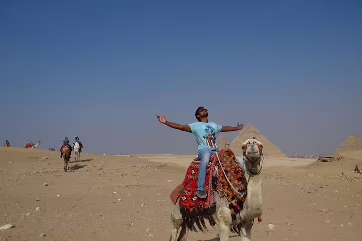 Camel ride in Giza Desert with the Pyramids in the background, included in a private 2-day Cairo tour for two