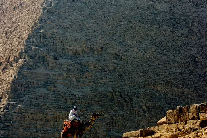 Camel rider beside the Great Pyramid of Giza stone blocks on Cairo day tour with Egypt Museum and Coptic Cairo