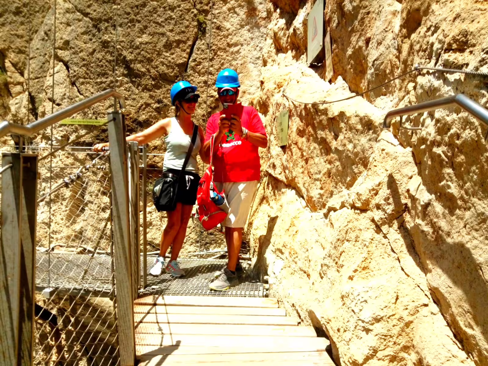 Hikers in helmets at the start of Caminito del Rey group walking tour on cliff walkway in El Chorro gorge