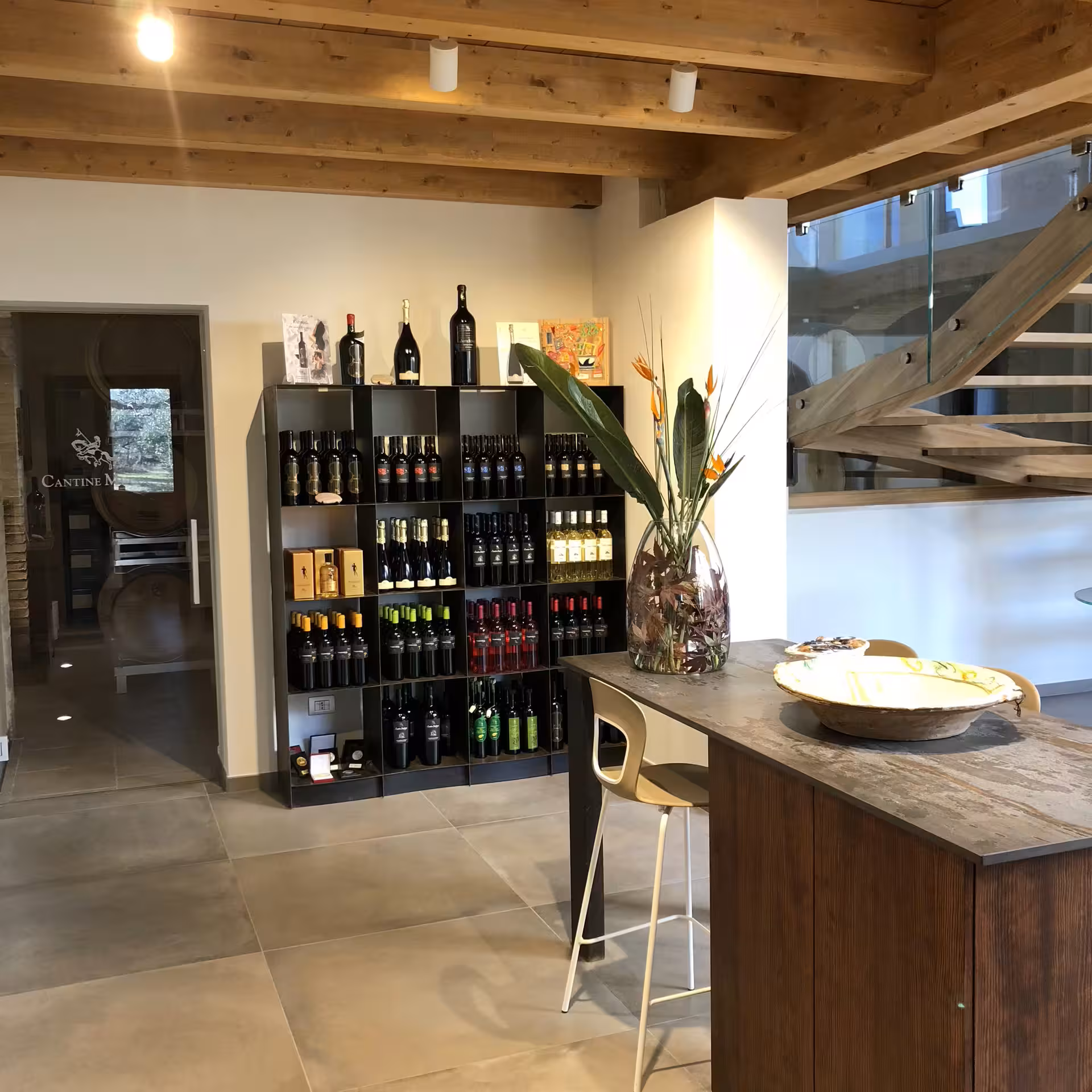 Cantine Mucci winery tasting room with wine display shelves and bar, ideal for vineyard tour and wine tasting