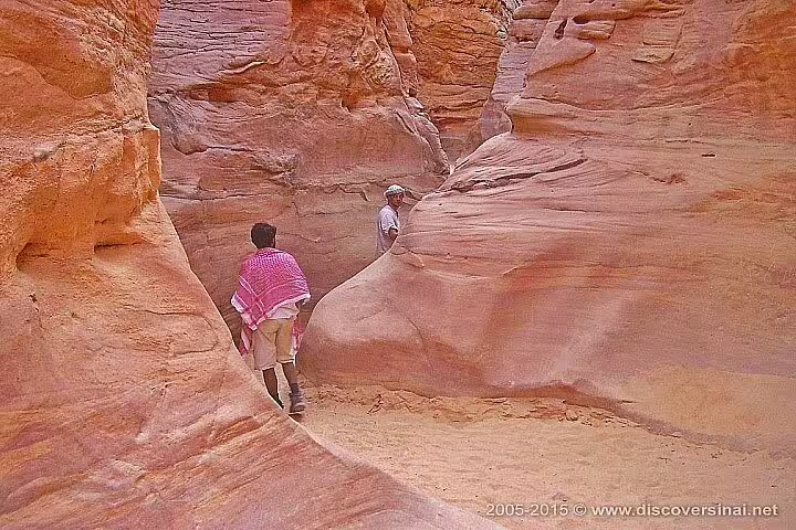 Travelers hiking through Canyon Salama sandstone gorge on Sharm el Sheikh to Dahab Jeep Safari day trip
