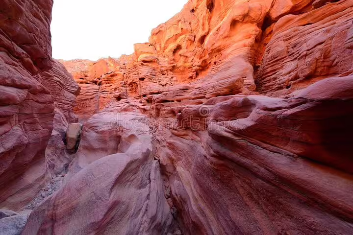 Narrow red sandstone gorge in Canyon Salama, visited on a Sharm el Sheikh jeep safari to Dahab day trip