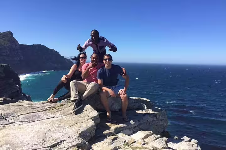 Group of friends enjoying the stunning ocean views from a cliff at Cape of Good Hope.