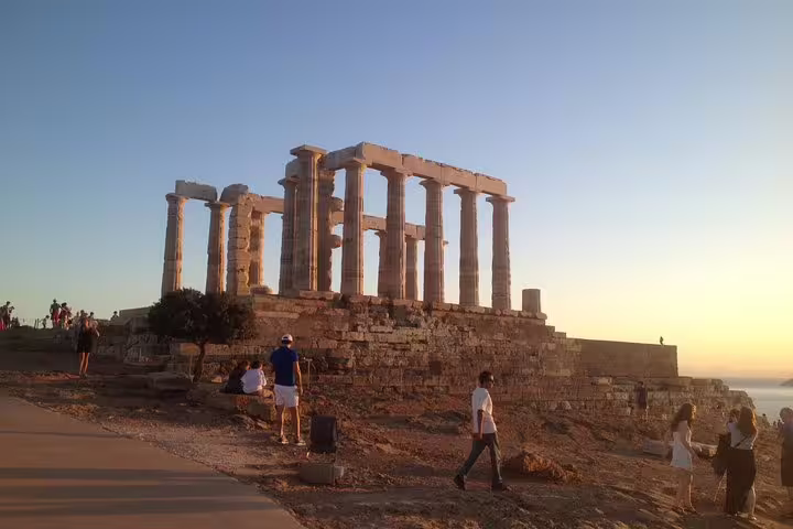 Visitors walking near the Temple of Poseidon at Cape Sounion during an Athens small-group sunset tour