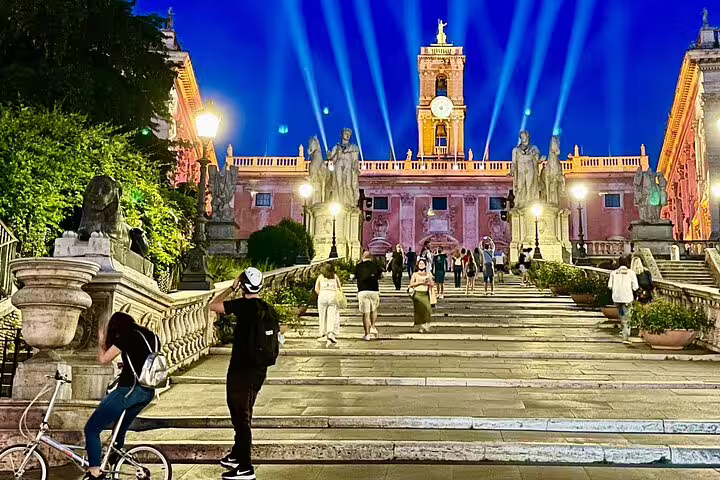 Capitoline Hill staircase at dusk with statues, night lights and visitors on a Rome by night private chauffeured tour