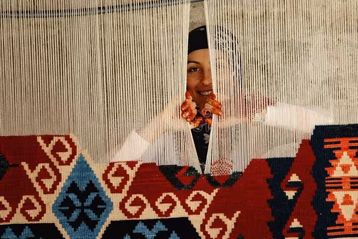 Artisan weaving a traditional Cappadocia kilim on a loom during a local shopping tour and craft workshop visit