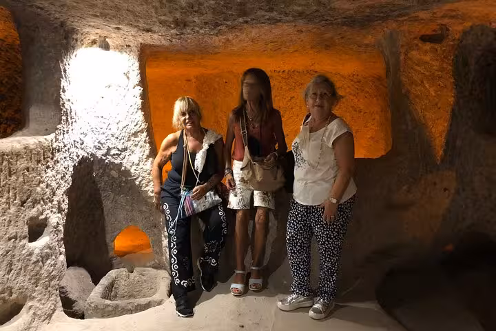 Visitors exploring Cappadocia cave interior on private guided tour with English speaking guide and car