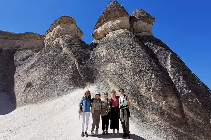 Travelers pose by Cappadocia fairy chimneys on full-day tour from Istanbul with hotel pickup and flights