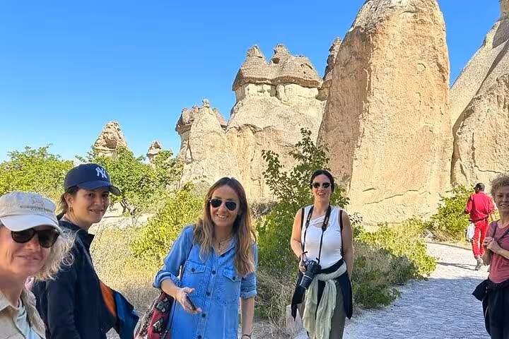 Visitors walk among Cappadocia fairy chimneys on guided day tour from Istanbul including flights and hotel