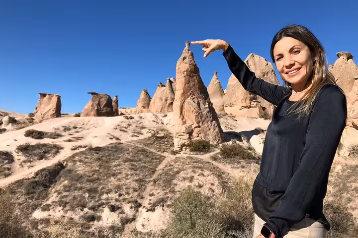 Traveler posing by Cappadocia fairy chimneys in Pasabag on 2-day small group North and South tour