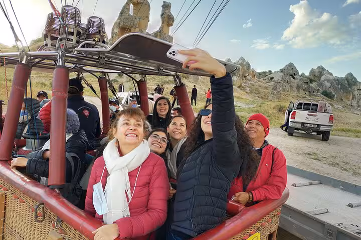 Guests take a selfie in a Cappadocia hot air balloon basket before flight, part of a private tour with English guide