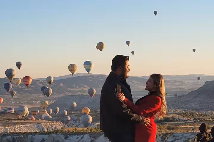 Couple watching Cappadocia hot air balloons at sunrise on private tour with English guide, luxury car