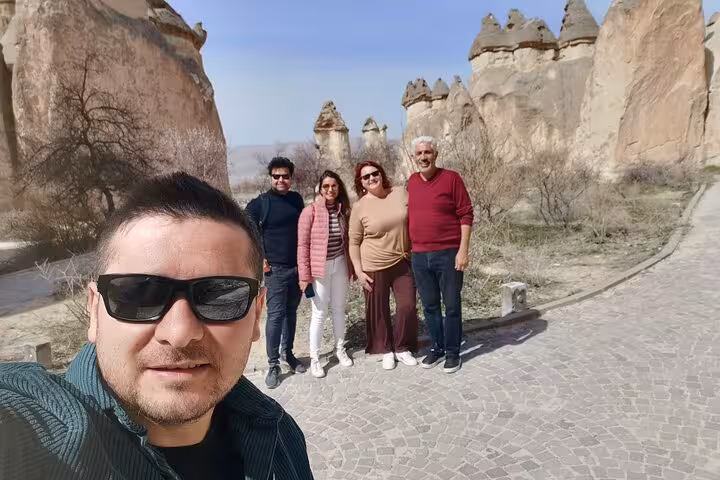Private Cappadocia tour from Istanbul by plane with travelers posing by fairy chimneys in Goreme