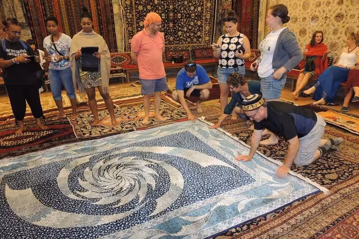 Travelers viewing handmade Turkish carpets in a Cappadocia rug showroom during the Best of Cappadocia shopping tour
