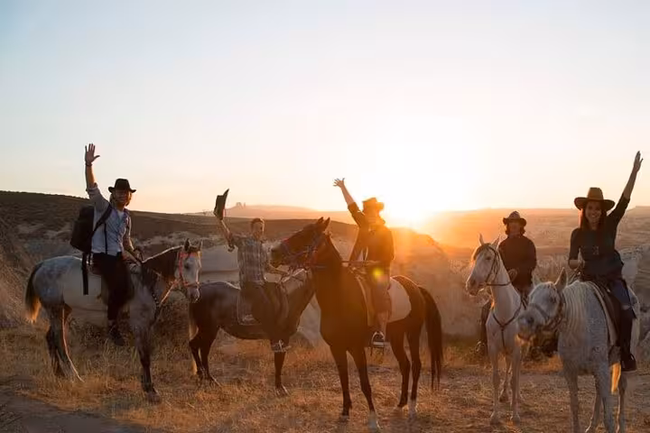 Group horseback riding at sunset in Cappadocia, Turkey, during a 2-hour guided valley tour with views