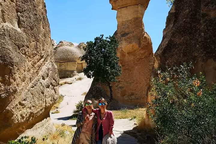 Travelers hiking Cappadocia rock valley on small group tour, exploring Göreme landscapes before lunch