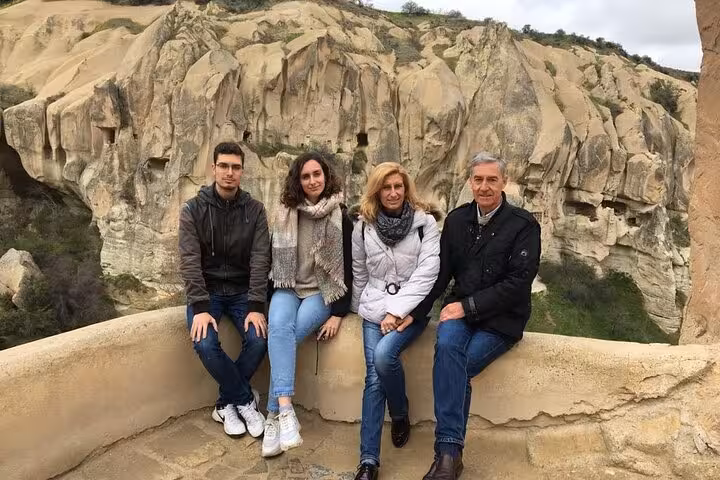 Small group Cappadocia tour guests at panoramic viewpoint with dramatic rock valleys and cave cliffs