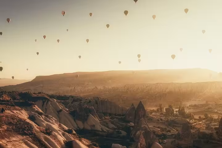 Panoramic Cappadocia valley at sunrise with hot air balloons, ideal for a private guided 2-day tour